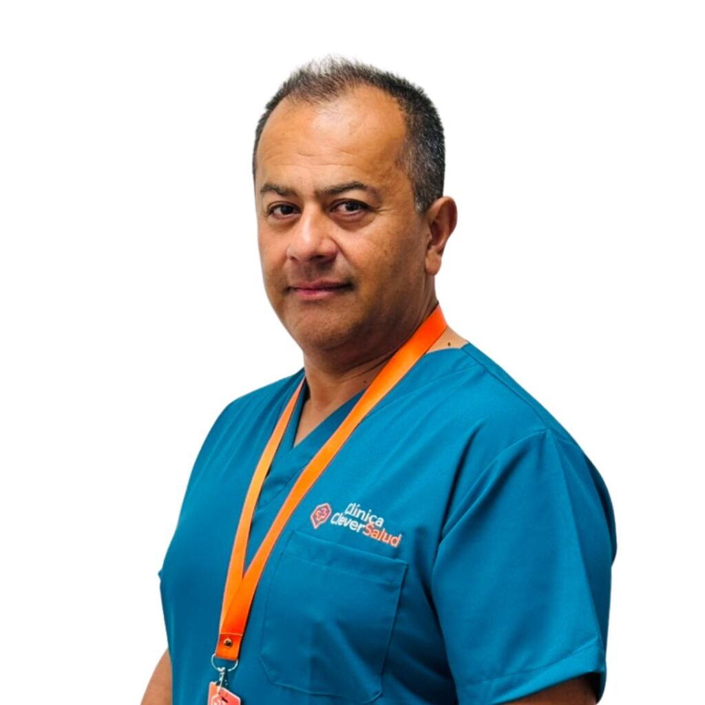 Male healthcare professional wearing blue scrubs and an orange lanyard, looking at the camera against a white background.