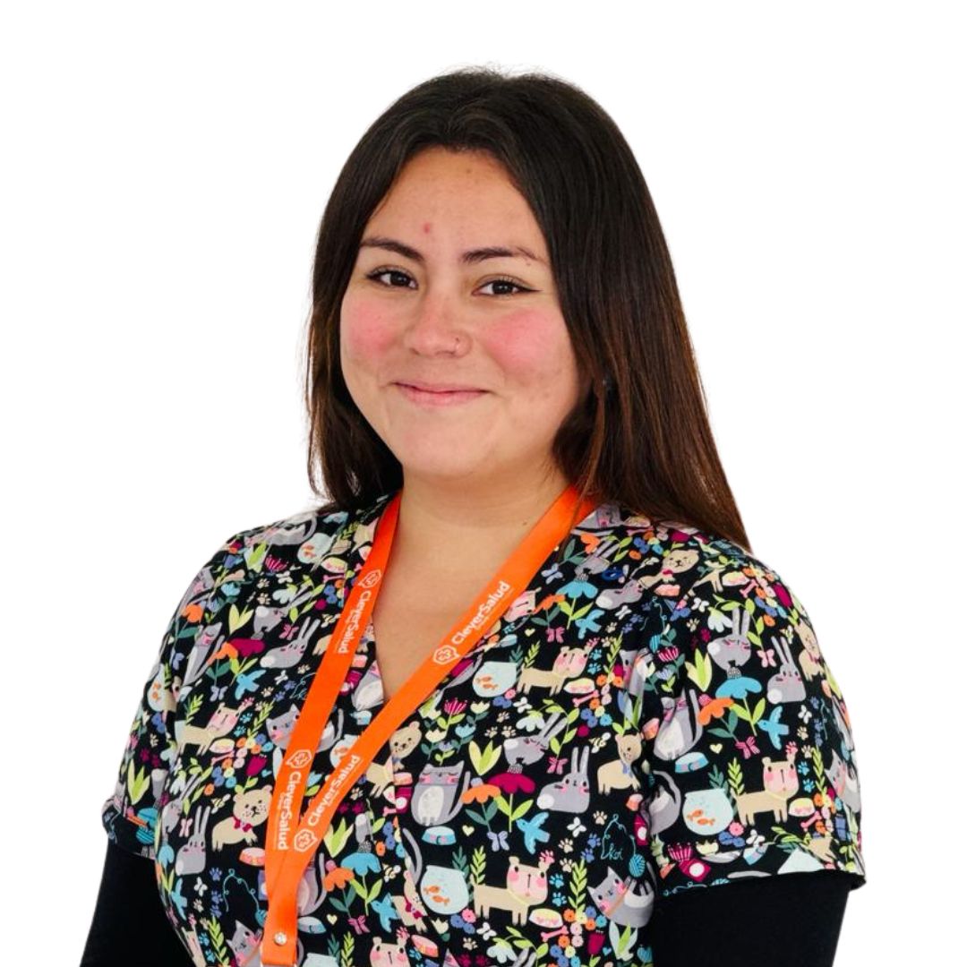 Smiling woman wearing a colorful animal-print scrub top and an orange lanyard, standing against a white background.