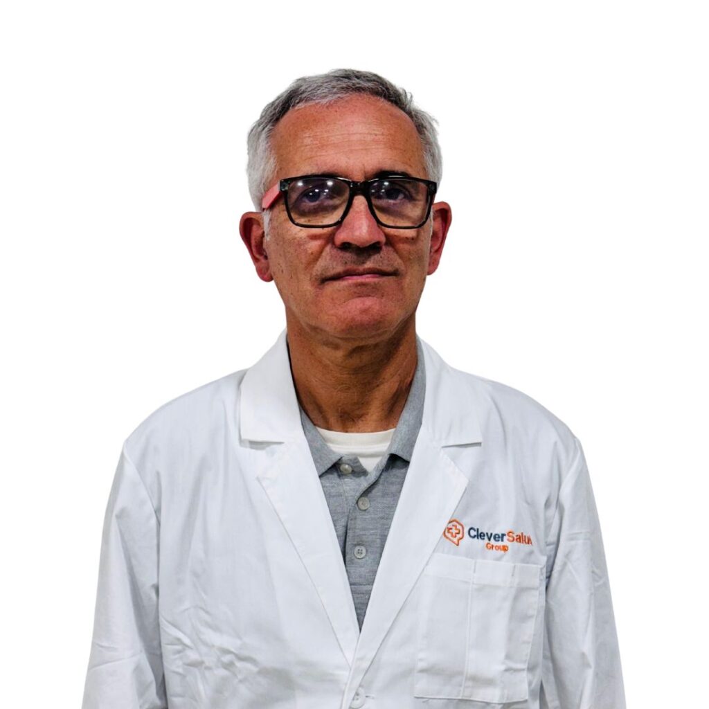 Male medical professional in a white lab coat looking at the camera, wearing glasses.