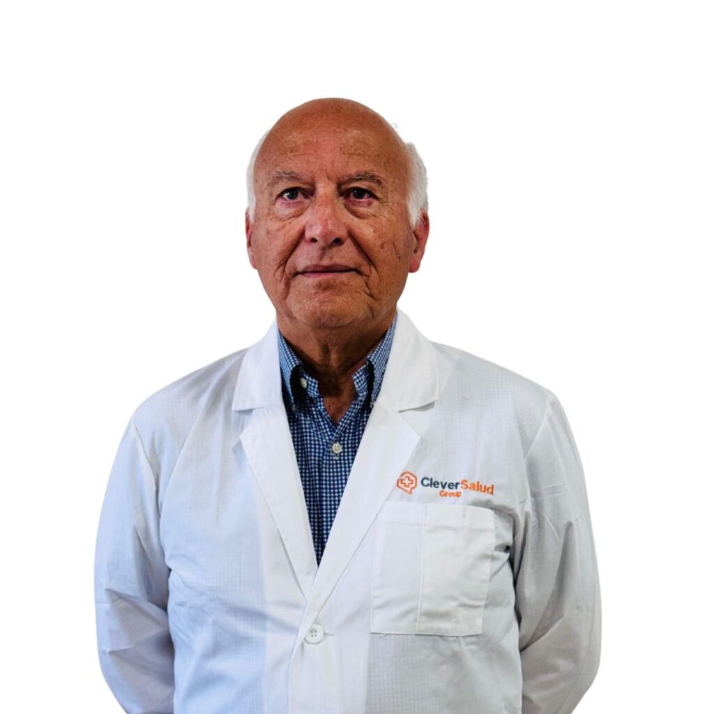 Senior clinician in a white lab coat with the CleverSalud logo, standing against a white background and facing the camera.