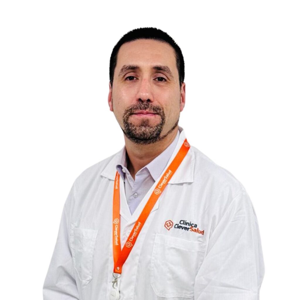 Portrait of a male clinician in a white lab coat, orange Clinica Clever Salud lanyard, facing the camera.
