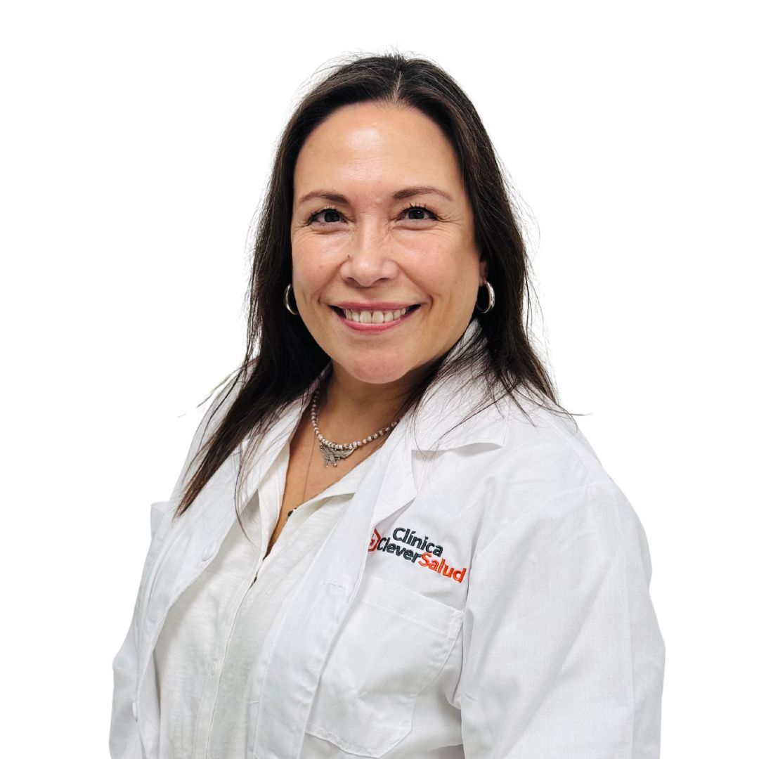 Smiling woman in a white lab coat with clinic logo on the chest, against a white background.