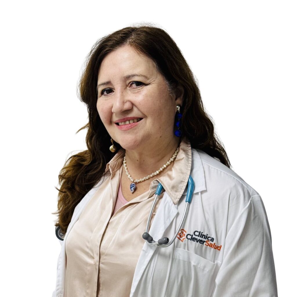 Smiling female doctor in a white coat with stethoscope, beige blouse, pearl necklace, and blue earrings, Clinica Clever Salud logo visible on the coat.