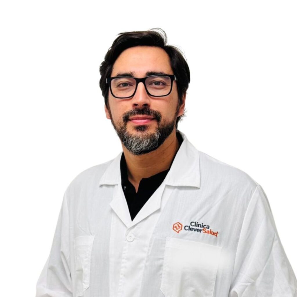 Male doctor with dark hair and glasses in a white lab coat, facing the camera; Clinica Clever Salud logo on the left chest.