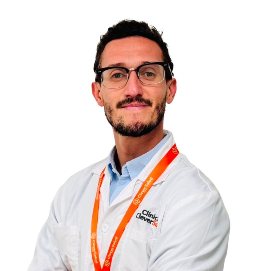 Portrait of a man wearing glasses, a white lab coat, and an orange lanyard, smiling slightly.