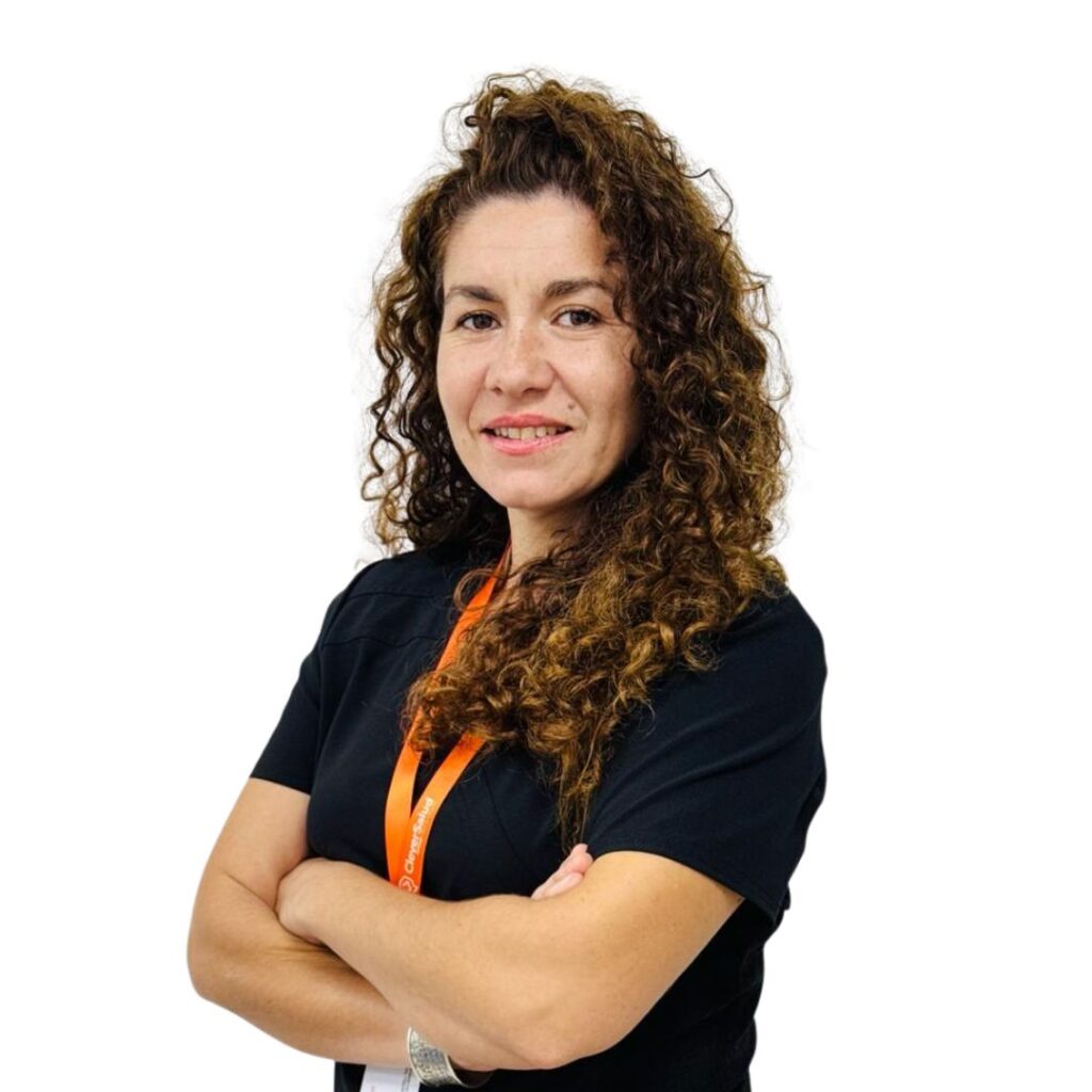 Portrait of a woman with long curly hair, arms crossed, wearing a black shirt and an orange lanyard.