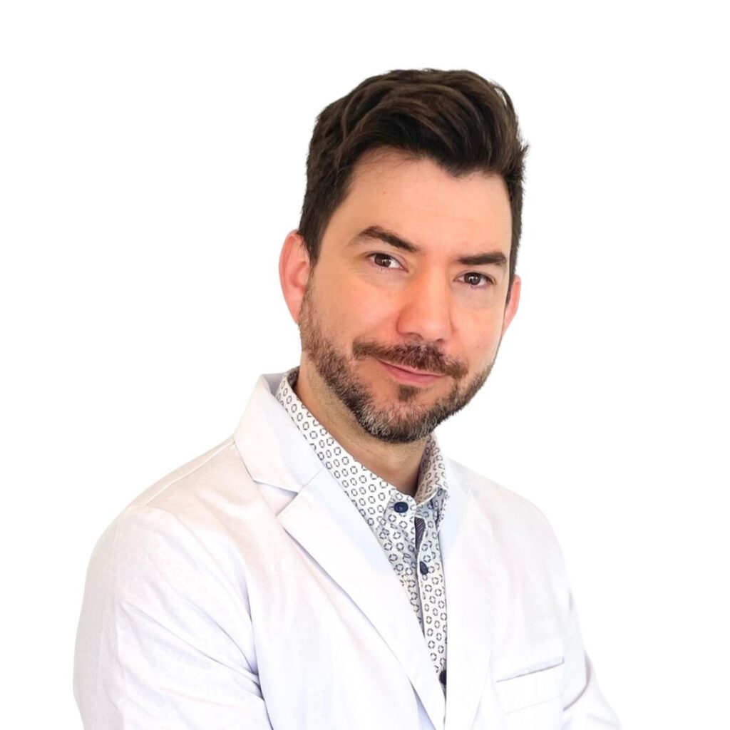 Portrait of a smiling man in a white coat looking at the camera, against a white background.