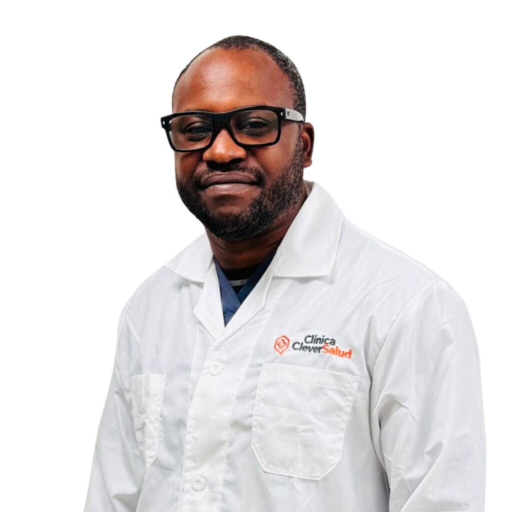 Smiling Black male doctor in a white coat with a Clinica Clever Salud logo on the chest pocket area.