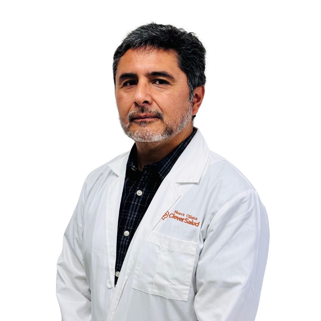 Portrait of a male doctor in a white lab coat over a dark plaid shirt, looking at the camera.