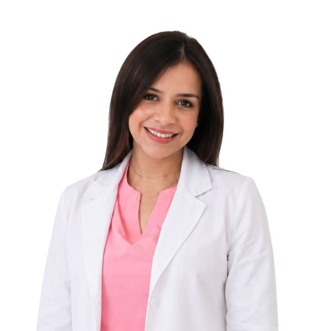Smiling woman in a white lab coat over a pink blouse, looking at the camera for a professional portrait.