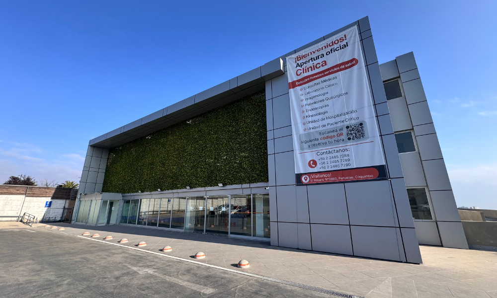 Front view of a modern clinic with a large vertical banner announcing the official opening.